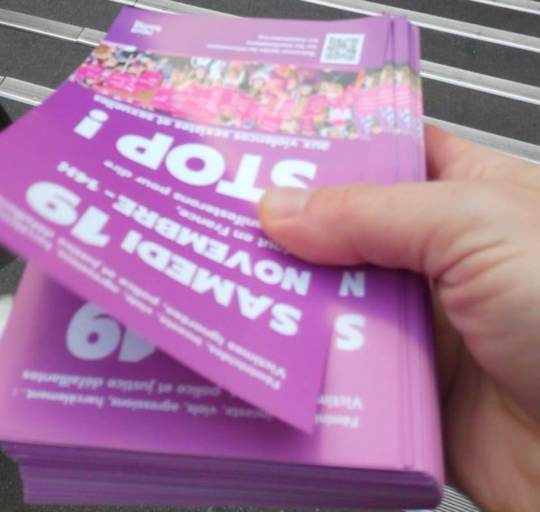 Paquet de tracts dans une main devant une bouche de métro.